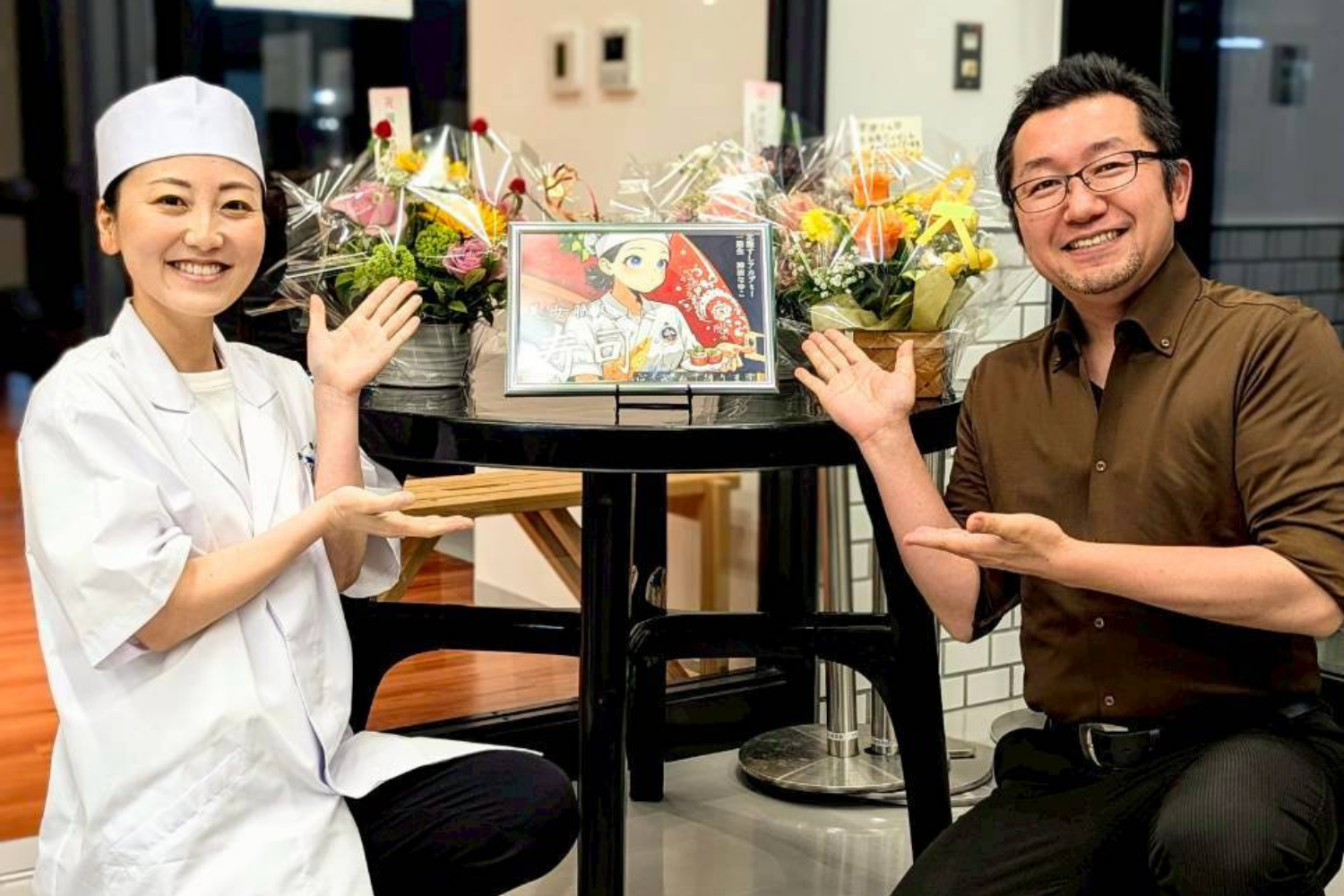 開店祝いの花に囲まれたシェフと男性