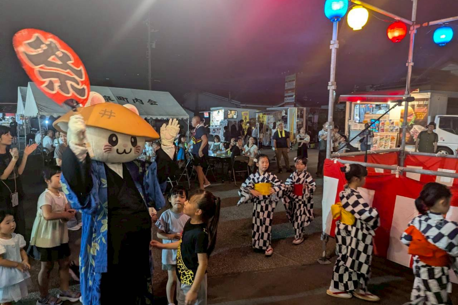 夏祭りで浴衣の人たちと並ぶばいにゃこさん