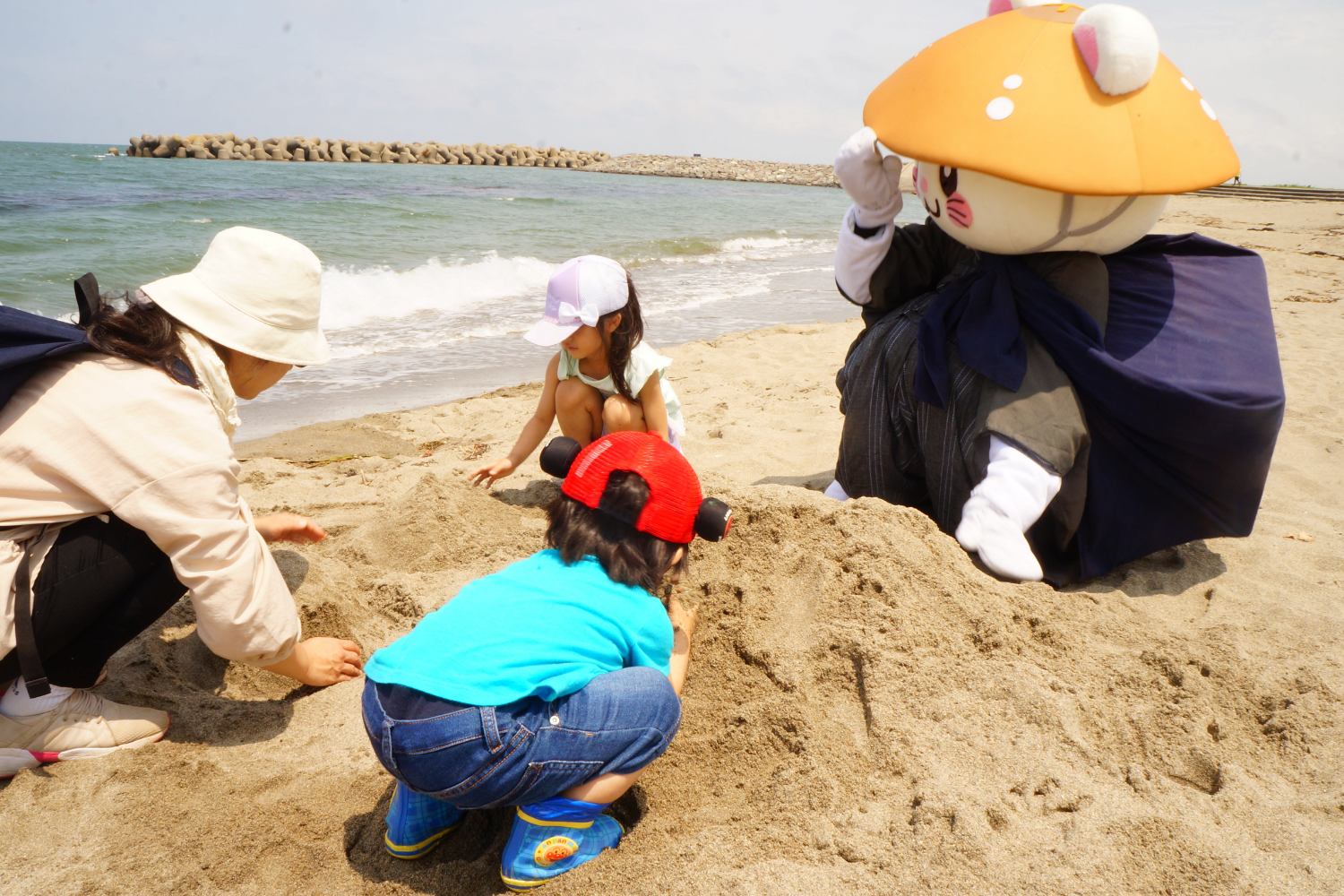 砂浜で子どもたちと遊ぶばいにゃこさん