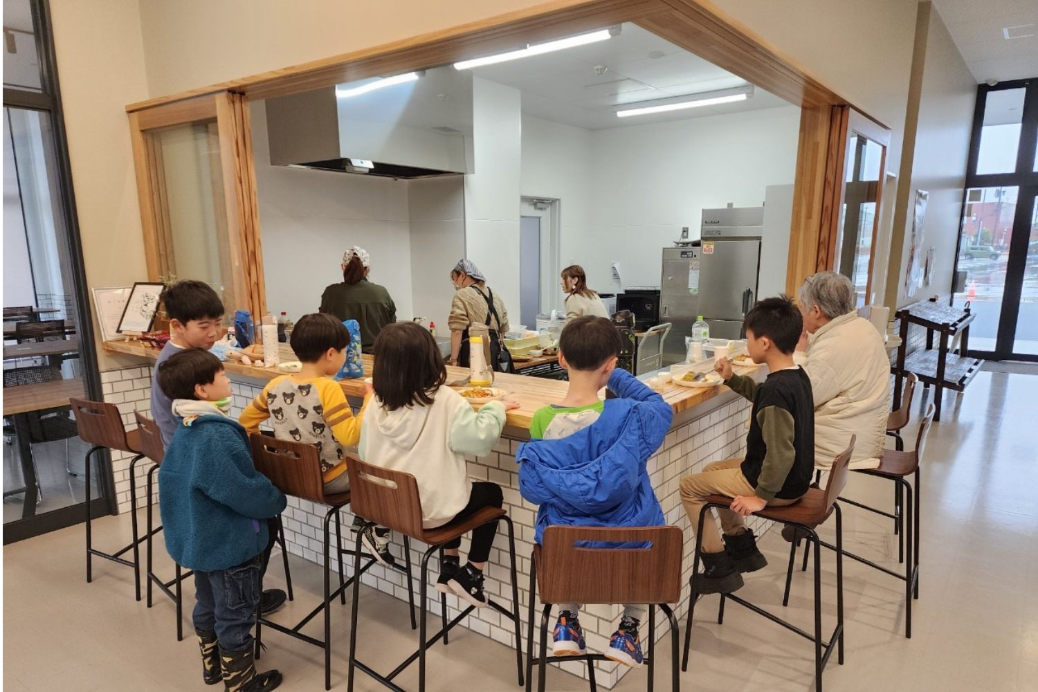 カウンターで食事する子どもと大人