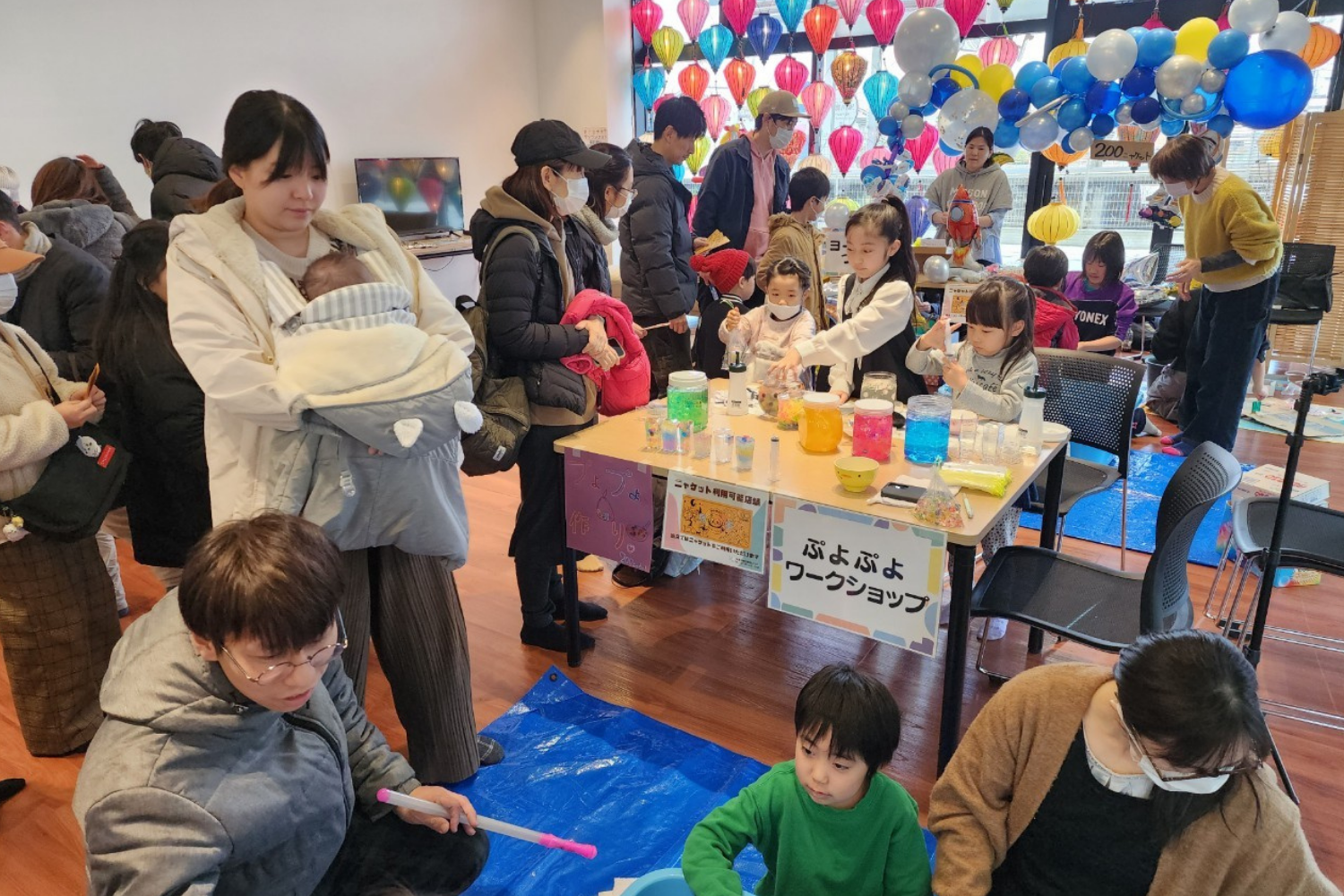 屋外テントでのワークショップに参加する親子
