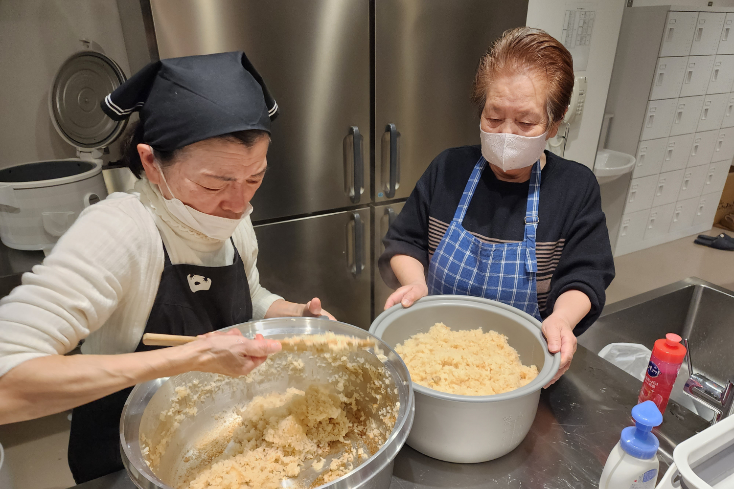 大鍋のご飯を混ぜるスタッフ