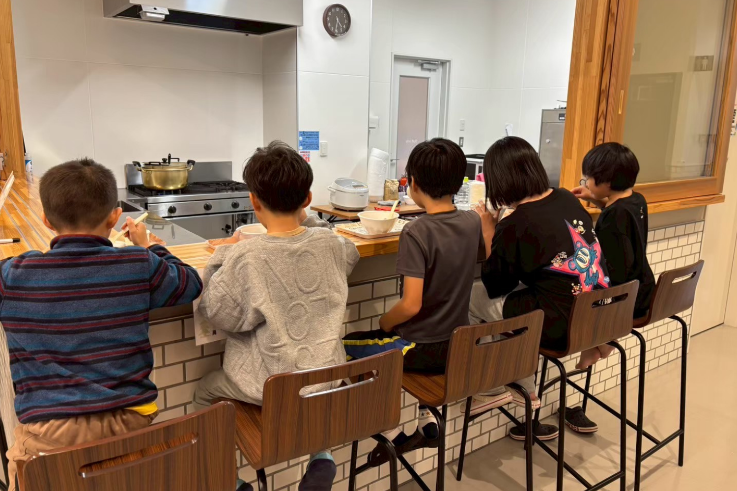 カウンターに並んで食事する子どもたち