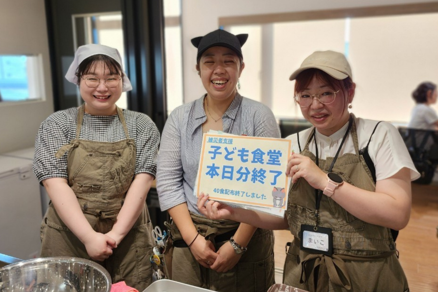 「子ども食堂 本日分終了」の札を持つスタッフ