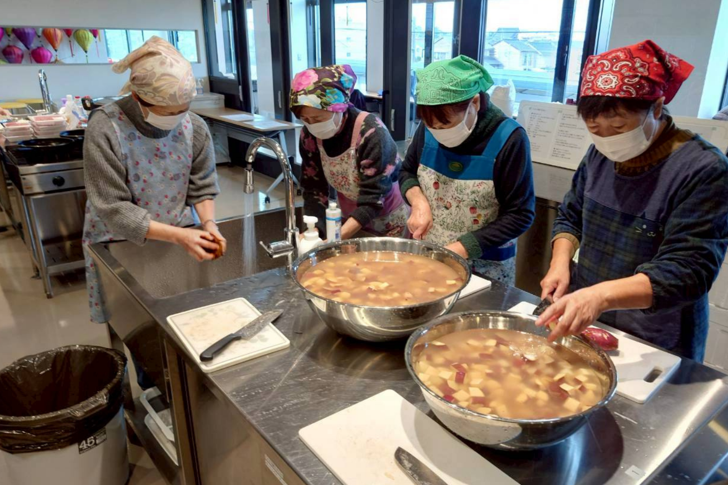 大鍋を囲んで調理するシニアメンバー