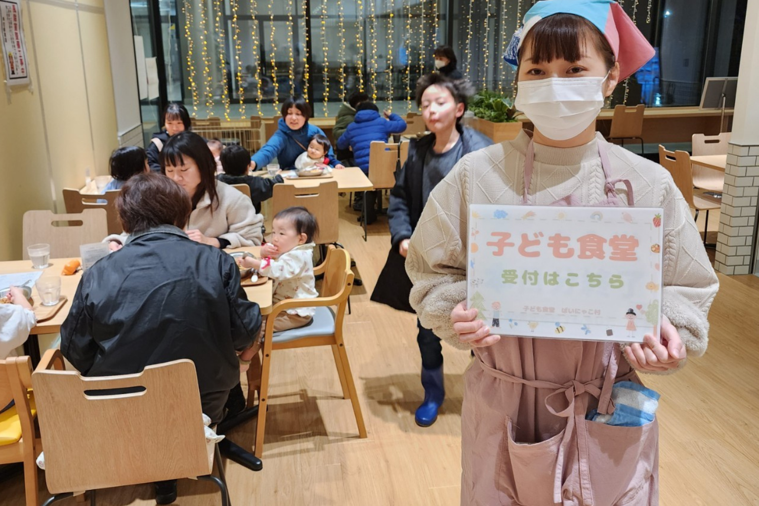 「子ども食堂 受付はこちら」の案内と来場者