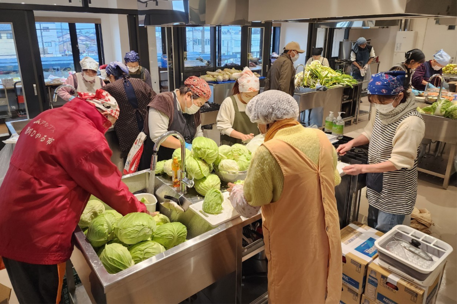 支援先で野菜を手渡すメンバー