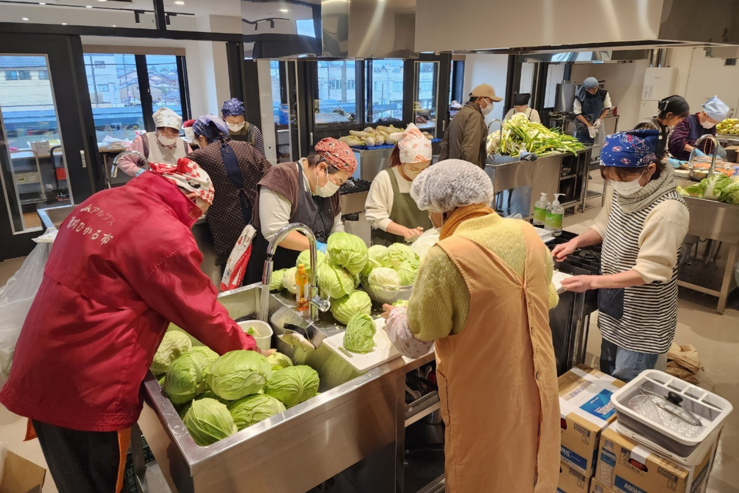 支援先で野菜を並べて手渡すメンバー