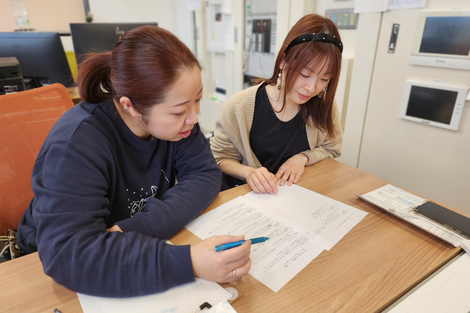 事務所で書類を確認するスタッフ